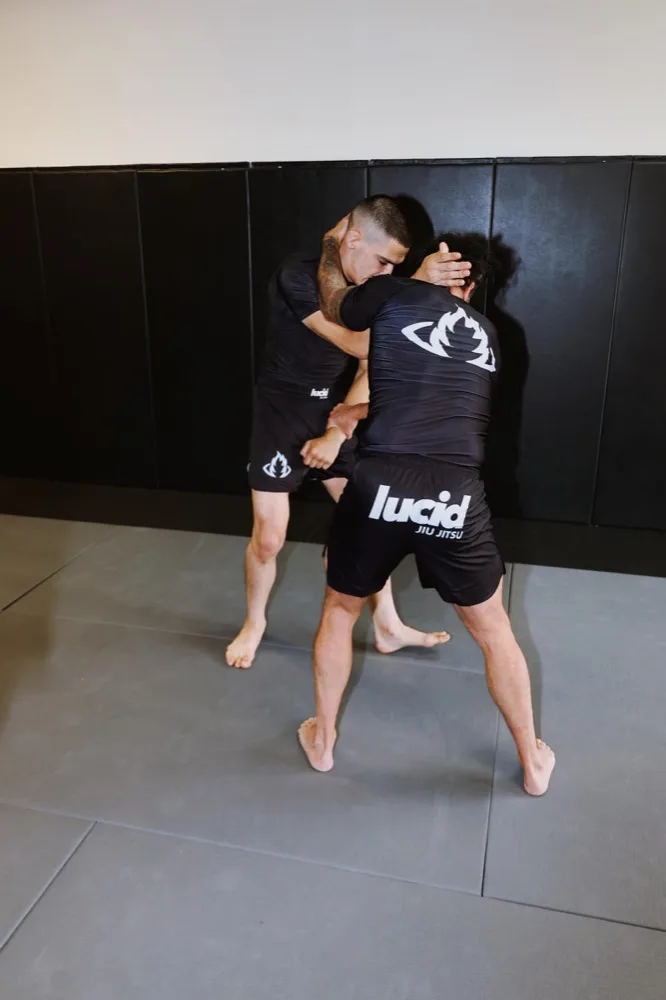 Coach working one-on-one with a student on positional drilling during a private jiu jitsu lesson at Lucid Jiu Jitsu